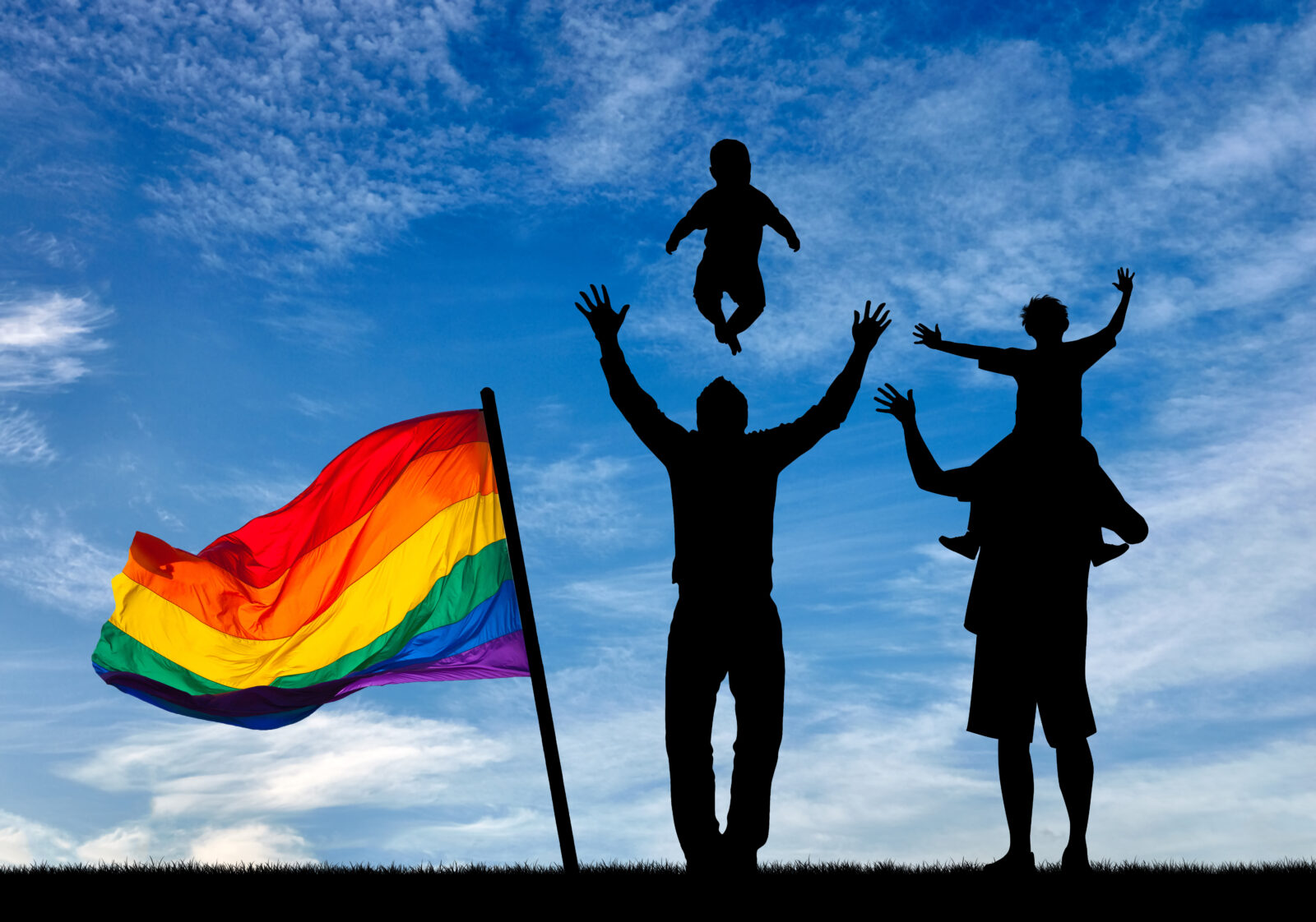 Silhouette of happy parents with rainbow flag